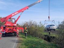 Dvaadvacet víkendových hodin s hasiči: Osoba v míchačce betonu, auto v potoce, požár auta a transport zraněného z nepřístupného terénu