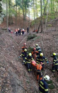 Dvaadvacet víkendových hodin s hasiči: Osoba v míchačce betonu, auto v potoce, požár auta a transport zraněného z nepřístupného terénu